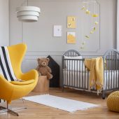 yellow-armchair-teddy-bear-and-crib-in-a-modern-ki-F5JHBNQ-scaled.jpg